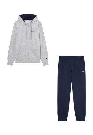 Felpa grigia con zip e fodera interna navy, abbinata a pantaloni della tuta navy con vita elastica e dettaglio del logo.