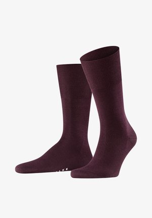 Calze in misto cotone color bordeaux con polsini a coste e texture liscia. Presentano una punta rinforzata e un branding sottile sulla suola.