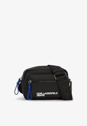 Borsa a tracolla nera realizzata in materiale morbido, con una tasca anteriore con zip, tirazip blu e una tracolla removibile con dettagli del logo.