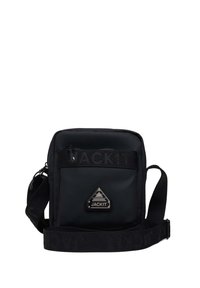 Zwarte schoudertas met een gladde textuur, voorzien van een voorzak met rits, een logo-patch en een verstelbare schouderband met "JACKIT" opdruk.