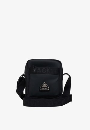 Zwarte schoudertas met een gladde textuur, voorzien van een voorzak met rits, een logo-patch en een verstelbare schouderband met "JACKIT" opdruk.