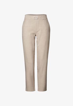 Pantaloni beige su misura con una texture liscia, dotati di una cintura elastica e un dettaglio in metallo argentato a forma rettangolare. Lunghezza alla caviglia, taglio cropped.