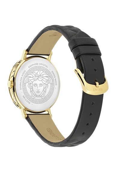 Złoty stalowy zegarek z czarnym skórzanym paskiem i fakturowaną powierzchnią. Biała tarcza z emblematem Meduzy i szafirowym szkłem.