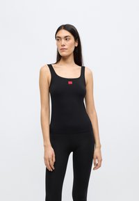 Μαύρο κοντομάνικο μπλουζάκι με στρογγυλή λαιμόκοψη, κατασκευασμένο από ελαστικό ύφασμα. Διαθέτει μικρή κόκκινη ετικέτα με λογότυπο στο κέντρο. Εφαρμοστή σχεδίαση.