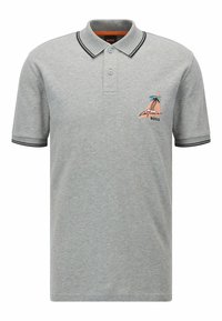 Šedé polo tričko vyrobené z bavlny s ribkovaným límečkem a manžetami. Obsahuje vyšívaný design modré a růžové barvy znázorňující hory a palmy.