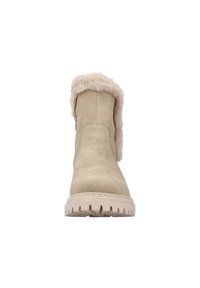 Bottines en suède beige avec une douce bordure en fausse fourrure, semelle plate en caoutchouc et un contraste de couture le long des coutures.