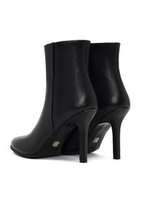 Bottines en simili cuir noir avec une silhouette élégante, un bout pointu, un talon aiguille haut et des accents de logo doré à l'arrière.