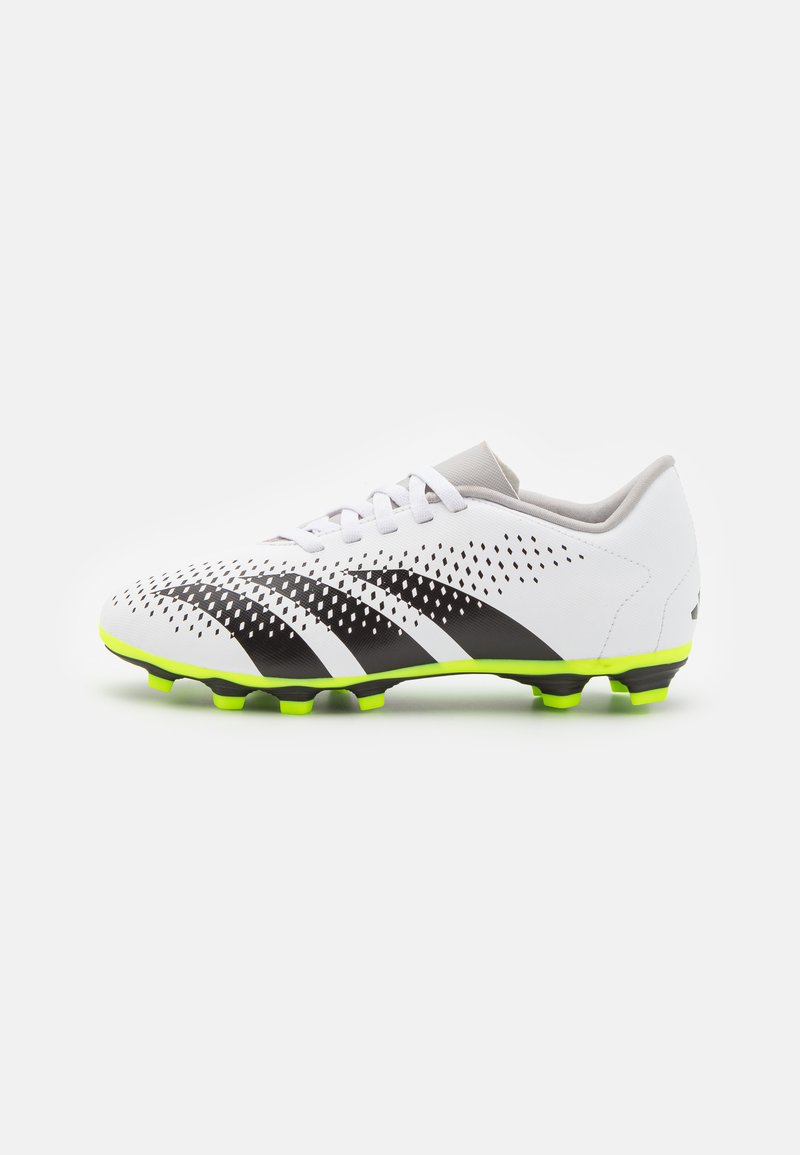Botas de fútbol blancas con rayas negras, parte superior perforada, cuello gris y suela de un vibrante color verde con tacos moldeados para tracción.
