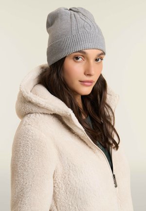 Bonnet en tricot gris avec un revers côtelé, présentant un design en torsades. Assorti à une veste en fausse fourrure crème avec capuche.
