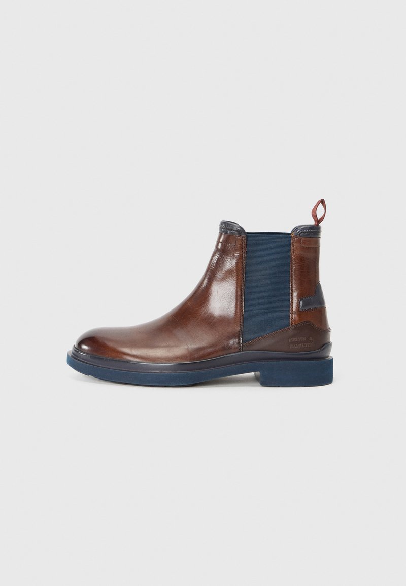 Bottines Chelsea en cuir marron avec des panneaux élastiques latéraux bleu, bout rond, tirette et détails texturés sur le talon et la semelle.