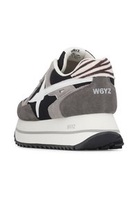 Gray and black W6YZ sneaker with white sole, white logo, and zebra-patterned heel tab viewed from the back right side.