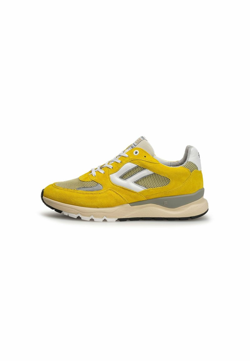Sneaker giallo brillante con pannelli in mesh e accenti grigi, dotato di lacci bianchi e suola in gomma, esposto su uno sfondo bianco neutro.