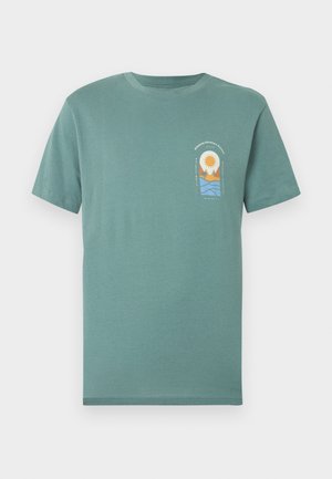 Grøn T-shirt med korte ærmer og et lille motiv af sol, bjerge og bølger på venstre bryst samt tekst over og under motivet.