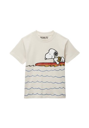 T-shirt blanc avec Snoopy portant un gilet de sauvetage jaune allongé sur une planche de surf rouge et jaune au-dessus des vagues bleues.