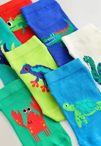 Calcetines infantiles coloridos con animales de dibujos animados que incluyen un cangrejo rojo, un cocodrilo verde, una tortuga azul y una rana morada.