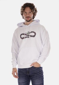 Hoodie bianco in cotone con tasca frontale, cordini e un design grafico che presenta un motivo vorticoso e un dettaglio con un occhio.