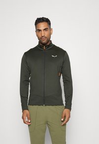 Dark green zip-up jacket made of smooth, stretchy fabric. Features a high collar, subtle logo, and orange zipper accents.