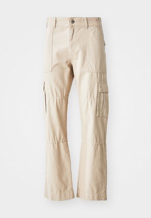 Beige Cargo-Hosen aus strapazierfähiger Baumwolle, mit mehreren Taschen, geradem Bein und sichtbaren Nähdetails.