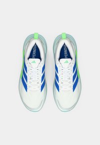 Par bijelih tenisica za trčanje s plavim prugama i zelenim detaljima, prikazanih odozgo na jednostavnoj bijeloj pozadini.