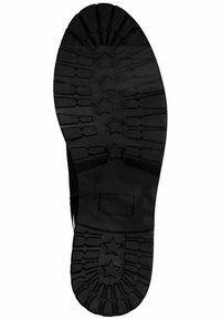 Suola di scarpa in gomma nera con un design della presa a motivo a stella, superficie testurizzata e bordi sagomati per una maggiore aderenza.
