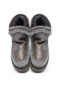 Un paio di pantofole grigie in stile mocassino con rivestimento in pelliccia morbida e cuciture decorative, viste dall'alto su uno sfondo bianco.