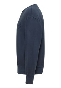 Sweatshirt bleu marine à col rond, avec poignets et ourlet côtelés. Présente un patch logo texturé sur la poitrine. Matière douce en mélange de coton.