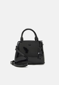 Svart patenterat läderhandväska med en strukturerad form, dubbla handtag upptill och en avtagbar axelrem. Har en märkesdetalj i metall.