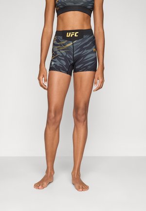 Black and gray patterned shorts with yellow UFC logo, fitted design, elastic waistband, and smooth texture, suitable for athletic wear.