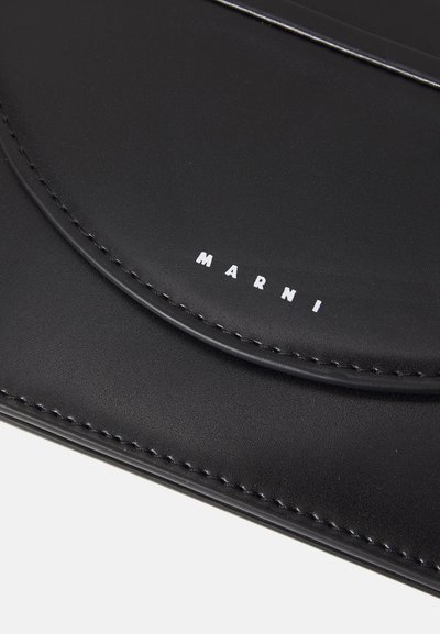 Juodas odinis portfelis su tekstūruota paviršiumi, turintis kreivą atvartą ir baltą „MARNI“ logotipą, įspaustą apačioje.