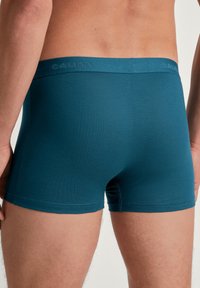 Teal mannenboxershorts met een gladde textuur, een elastische tailleband met CALIDA-logo en een nauwsluitend ontwerp.