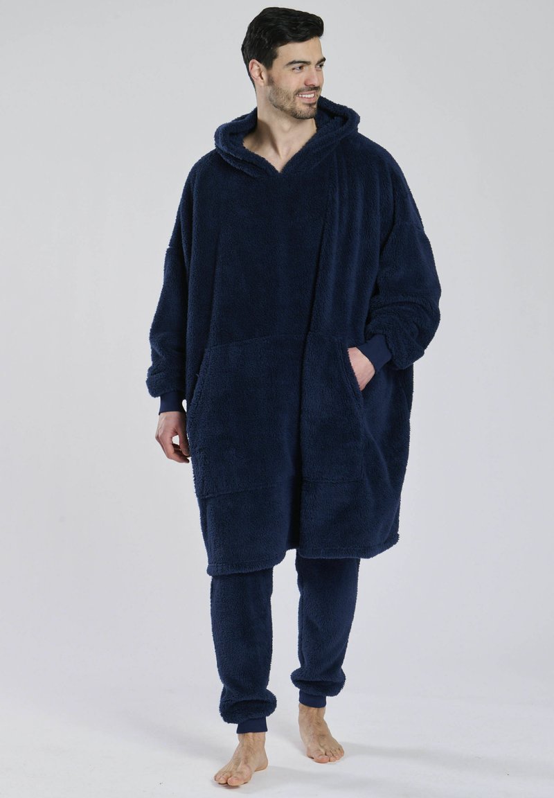 Marineblå fleece poncho med hætte, stor frontlomme og lange ærmer, parret med matchende fleecebukser. Blød tekstur og afslappet pasform.