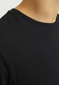 Schwarzes Baumwoll-T-Shirt mit klassischem Rundhalsausschnitt und kurzen Ärmeln, mit glatter Textur und minimalen Nähdetails.