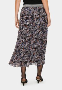 Maxiklänning med blommönster och svängande design. Har ett silverfärgat elastiskt midjeband och ett lätt, texturerat tyg.