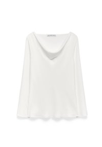 Top bianco a maniche lunghe con scollatura a collo, realizzato in tessuto morbido. Presenta maniche ampie e una silhouette rilassata, senza hardware visibile.