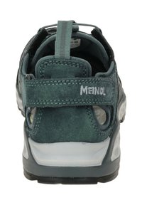 Grüner Wildlederschuh für den Außenbereich mit einem Obermaterial aus Mesh, verstärktem Fersenbereich, verstellbarem Riemen und einer strukturierten Gummisohle. Logo auf der Rückseite sichtbar.