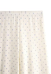 Pyjamasbyxor i krämfärgad tyg med vertikala ränder, med små blå blommönster och en elastisk midja.