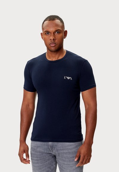 Granatowy t-shirt z krótkim rękawem wykonany z gładkiej bawełny. Posiada małe logo na piersi oraz klasyczny okrągły dekolt.