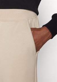 Champion ICONS CUFF PANTS LARGE LOGO - Spodnji deli trenirk - beige