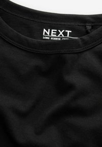 Zwarte langgevlekte crew neck t-shirt gemaakt van zachte katoen. Gecalibreerde textuur met een eenvoudig ontwerp en een label met de merknaam "NEXT."