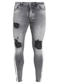 Slim-fit grå denimjeans med slitna lappar, vita sidstripes och en bleknad textur. Har standard knapplås och dragkedja.