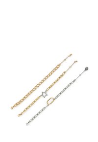 Quattro bracciali intrecciati: due catene dorate, una con un dettaglio a stella; una catena argentata con anelli ovali. Diverse forme e texture.
