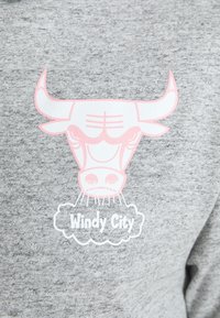Grijze sweatshirt met een roze stierafbeelding met gestileerde kenmerken en de tekst "Windy City" in het wit eronder. Zacht, textuurstof.