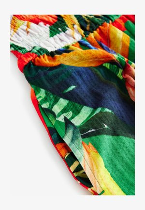 Tissu à motifs colorés présentant des nuances vives de vert, d'orange et de bleu. Détails de smocks et texture douce. Drapeau léger et fluide.