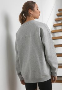 Hall grey kapuutsärkk on mugava lõikega, ribakäeotste ja vöökohtaga, millel on seljal tagasihoidlik tikitud "self." logo.