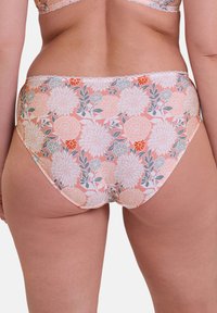 Culotte de couleur pastel orange à motifs floraux avec une finition en dentelle. Présente de grandes fleurs blanches et corail sur un fond clair. Tissu doux et extensible.