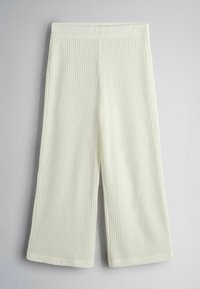 Krémové široké pletené kalhoty s žebrovanou texturou a elastickým pasem, položené na neutrálním pozadí.