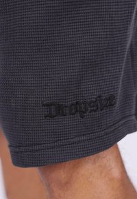 Graue, strukturierte Shorts mit einem gewebten Muster und einem gestickten "Dropside"-Logo in kontrastierendem Schwarz am Saum.