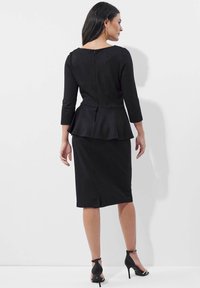 Schwarzes Peplum-Kleid mit Dreiviertelärmeln, runder Halslinie, Reißverschluss hinten und figurbetonendem Bleistiftrock-Silhouette.