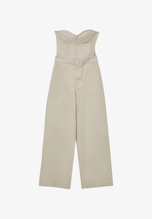 Tutina in cotone beige con un corpetto strutturato senza spalline, chiusura con zip frontale e design a gamba larga; include due tasche laterali.