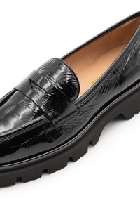 Mocassino in pelle verniciata nera con finitura testurizzata, una fascia larga sul davanti e una suola spessa e robusta per una maggiore trazione.